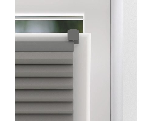 Detailaufnahme eines grauen Plissees am Fenster.