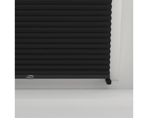 Schwarzes Faltrollo im Fensterrahmen zur Lichtregulierung und als Sichtschutz.