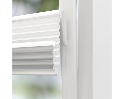 Detailansicht einer weißen Plisseejalousie am Fenster