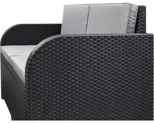 Nahaufnahme eines schwarzen Rattan-Gartensofas mit grauen Kissen