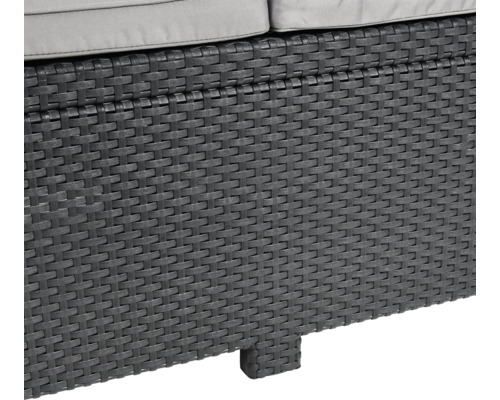 Detailansicht eines grauen Rattanmöbelstücks mit Polsterauflage