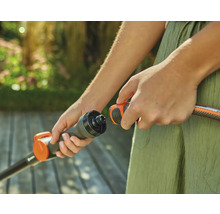 Person verbindet Gartenschlauch mit einem Anschlussstück.
