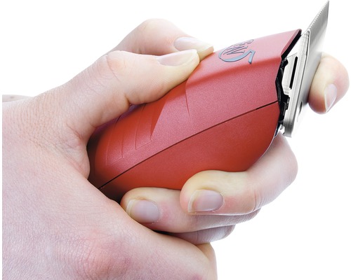 Eine Hand hält eine rote Haarschneidemaschine.