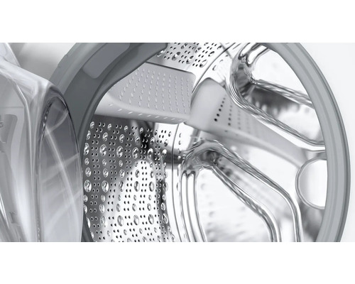 Innenansicht einer Waschmaschinentrommel aus Edelstahl mit Löchern.