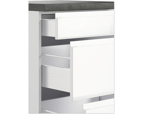 Detailaufnahme eines weißen Badezimmerschranks mit offenen Schubladen und grauer Arbeitsplatte