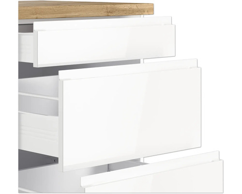 Detailansicht eines weißen Badezimmerschranks mit Schubladen und einer Holzplatte