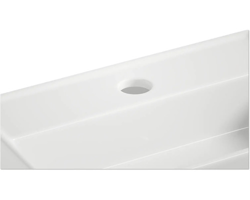 Detailansicht eines weißen Waschbeckens mit Hahnloch