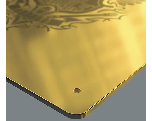 Detailansicht einer goldenen Metallplatte mit Ornament und Bohrloch.