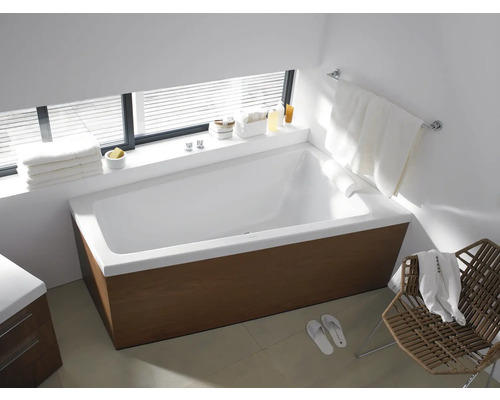 Modernes Badezimmer mit Badewanne, Handtüchern und Stuhl