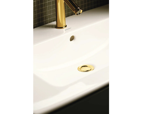 Aufnahme eines Waschbeckens mit goldfarbener Armatur und Abfluss