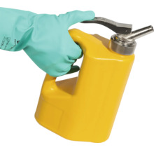 Eine Hand mit Schutzhandschuh hält einen gelben Sicherheitskanister.