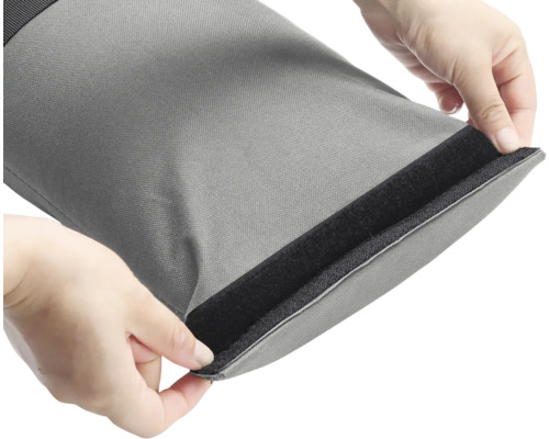 Graue Tasche mit Klettverschluss wird von Händen geöffnet.