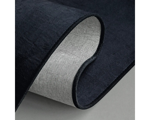 Detailansicht eines dunklen Teppichs mit gewebter Rückseite