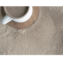 Nahaufnahme eines hochflorigen Teppichs mit Tasse
