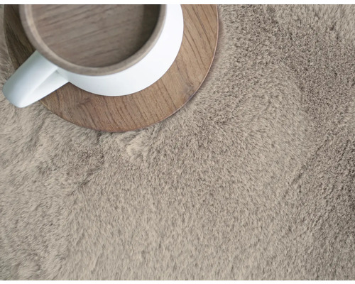 Nahaufnahme eines hochflorigen Teppichs mit Tasse