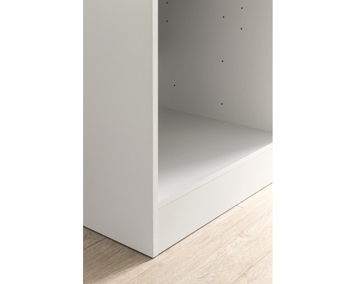 Detailansicht eines offenen, weißen Regals auf einem hellen Holzboden.