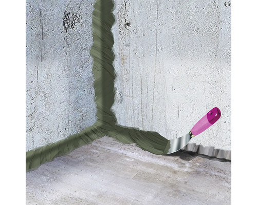 Reparieren von Mauerrissen mit Spachtelmasse und Spachtel