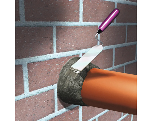 Illustration einer Person, die eine Mauerdurchführung mit einem Fugenfüller abdichtet