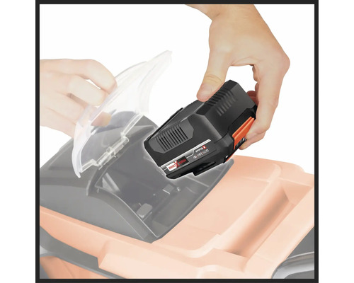 Ein Mann setzt einen Akku in einen Rasenmäher ein.