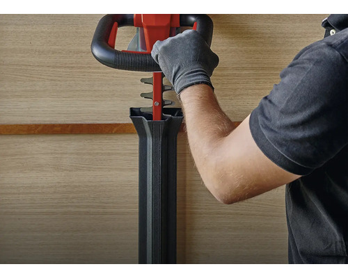 Bedienung einer Heckenschere durch eine Person mit Handschuhen.