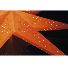 Nahaufnahme eines beleuchteten Papiersterns mit Lochmuster und dekorativen Ornamenten