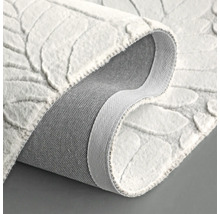 Weißer Teppich mit Blattmuster, gerollt dargestellt