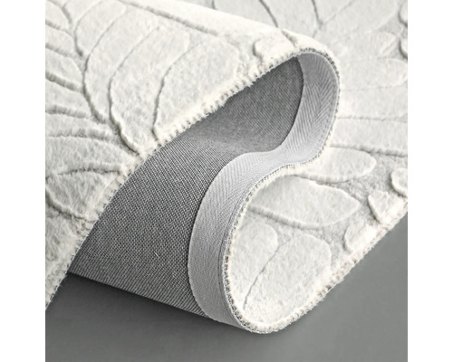 Weißer Teppich mit Blattmuster, gerollt dargestellt