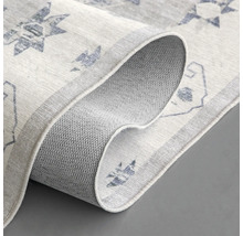 Detailansicht eines hellen Teppichs mit Muster und rutschfester Unterseite