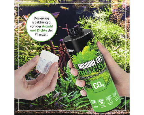 Microbe Lift Bio CO2 Flüssigdünger in einer Hand, Dosierbecher in der anderen, im Hintergrund ein Aquarium mit Pflanzen.