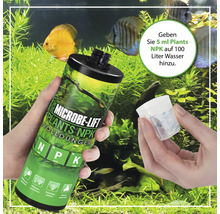 Microbe Lift Plants NPK Volldünger wird in der Hand vor einem Aquarium gezeigt.