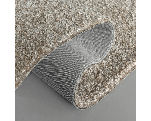 Detailansicht eines beigen Teppichs mit gekräuselter Oberfläche und grauer Rückseite.