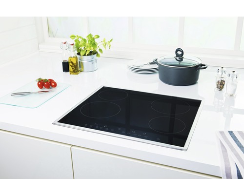 Induktionskochfeld in einer hellen Küche mit Kochtopf, Gewürzen und Zutaten