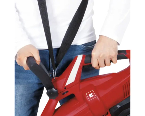 Person hält einen roten Laubsauger mit Tragegurt in der Hand.