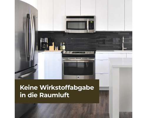 Helle Küche mit Edelstahlgeräten und dunklem Fliesenspiegel