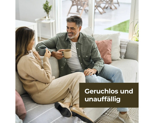 Ein Paar sitzt auf einem Sofa und hält Tassen