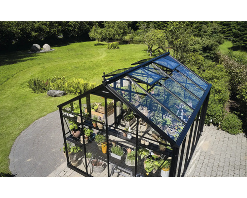 Gewächshaus mit Pflanzen und geöffneten Fenstern im Garten