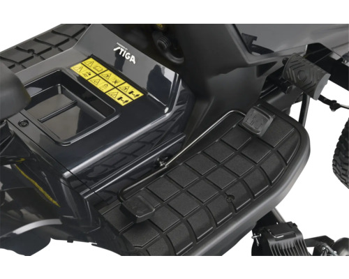 Detailaufnahme eines Rasentraktors mit Fußpedal und Warnhinweisen