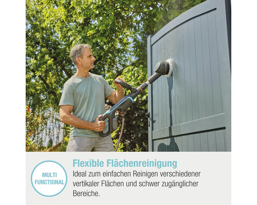 Mann reinigt mit einer Akku-Flächenbürste eine Tür im Außenbereich.