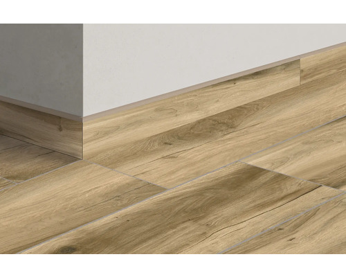 Bodenfliesen in Holzoptik mit passender Sockelleiste an einer Wand