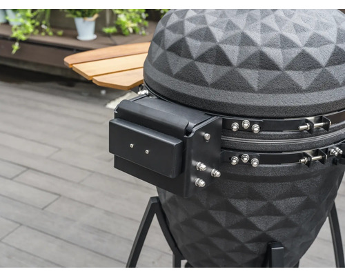 Detailaufnahme eines schwarzen Kugelgrills mit Ablagefläche