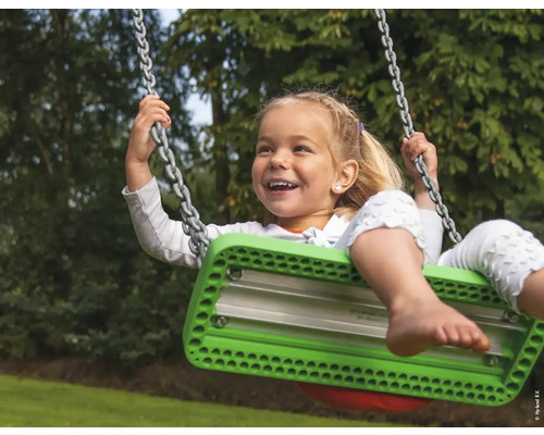 Lachendes Mädchen schwingt auf einer Schaukel mit Kettenaufhängung im Garten.