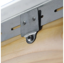 Detailaufnahme einer Metallschiene, die mit einer Halterung und einer Schraube an einem Holzbrett befestigt ist.