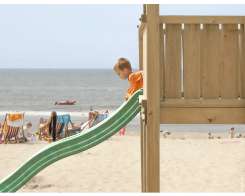 Kind auf einer Rutsche an einem Strandspielplatz