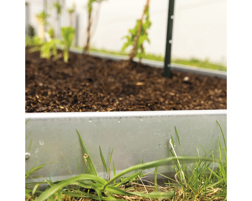 Hochbeet mit Pflanzen und Erde im Garten