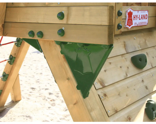 Detailansicht eines Spielturms mit Kletterwand aus Holz und grünen Haltegriffen