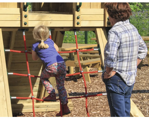 Mädchen klettert auf Spielgerät mit Netzstruktur, während eine Frau zusieht.