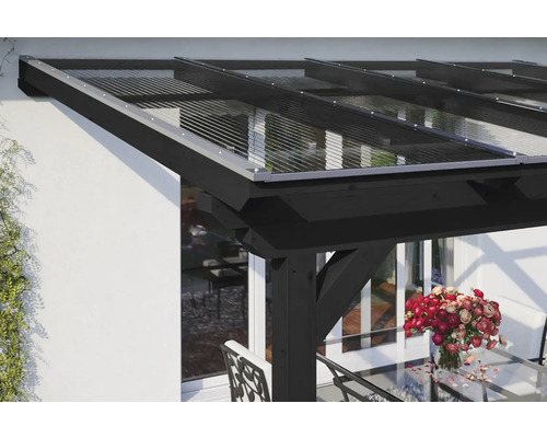 Terrassenüberdachung mit transparentem Dach und schwarzem Holzrahmen an einem Wohnhaus