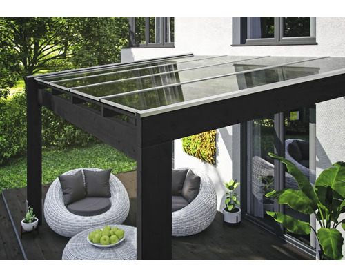 Terrassenüberdachung mit Glasdach und Sitzgruppe im Garten
