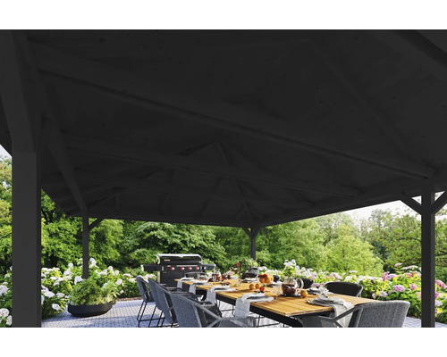 Überdachte Terrasse mit Esstisch und Grill im Hintergrund