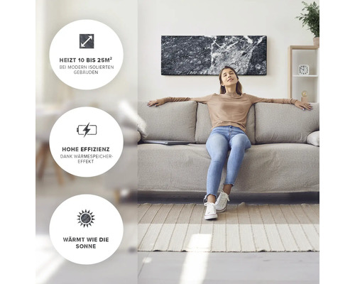 Eine Frau entspannt auf einem Sofa unter einer Infrarotheizung in Marmoroptik.